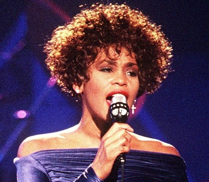 **FILE** Whitney Houston performs "Greatest Love of All" on March 31, 1991, during the HBO-televised concert "Welcome Home Heroes with Whitney Houston" honoring the troops, who took part in Operation Desert Storm, their families, and military and government dignitaries. (PH2 Mark Kettenhofen via Wikimedia Commons)