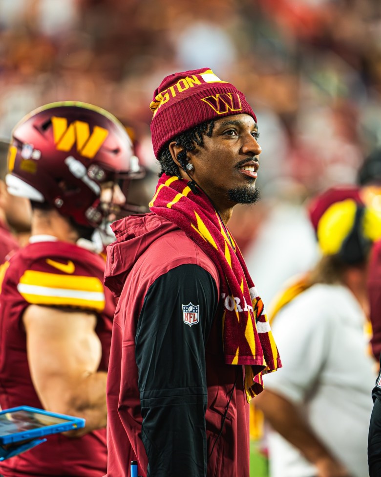 Washington Commanders quarterback Jayden Daniels watches from the sidelines after suffering a rib injury during the Commanders' 40-7 win over the Carolina Panthers at Northwest Stadium in Landover, Maryland, on Oct. 20. (Abdullah Konte/The Washington Informer)