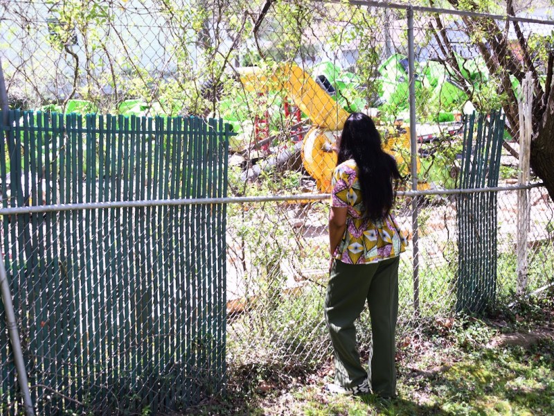 An Opus Avenue resident looks out at the garbage cans, construction equipment and other items kept in storage on the property that abuts her yard on April 16. (Anthony Tilghman/The Washington Informer)