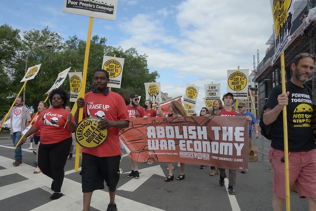 **FILE** A man holds up a sign during the 19th Annual MLK Parade in January 2024. Spreading the importance of financial literacy throughout the Black community — among all ages — is a key way to close the racial wealth gap and combat injustices overall. (Ja’Mon Jackson/The Washington Informer)