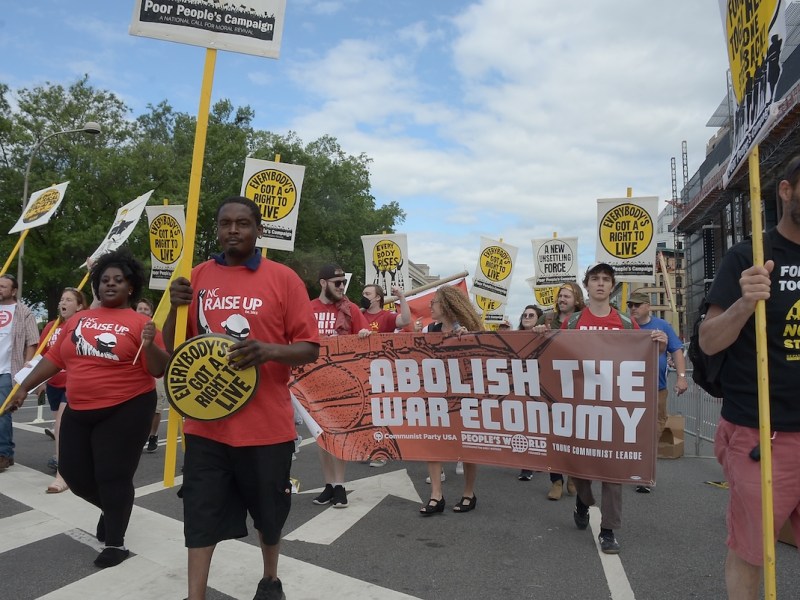 **FILE** A man holds up a sign during the 19th Annual MLK Parade in January 2024. Spreading the importance of financial literacy throughout the Black community — among all ages — is a key way to close the racial wealth gap and combat injustices overall. (Ja’Mon Jackson/The Washington Informer)