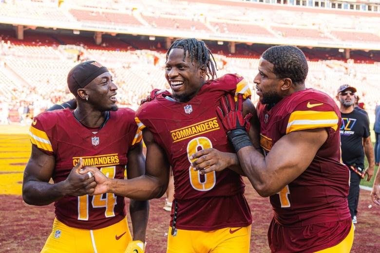 From left: Washington Commanders' Olamide Zaccheus, Brian Robinson and Bobby Wagner celebrate after the Commanders' 34-13 win over the Cleveland Browns at Northwest Stadium in Landover, Maryland on Oct. 6. (Abdullah Konte/The Washington Informer)