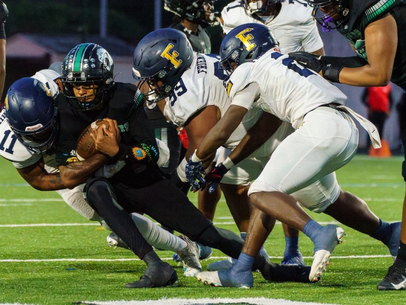 Friendship defense swarm Jaguars quarterback Adrian Favors (1) during their 14-0 victory over C.H. Flowers in Springdale, Md., on Sept. 6. (Marcus Relacion/The Washington Informer)