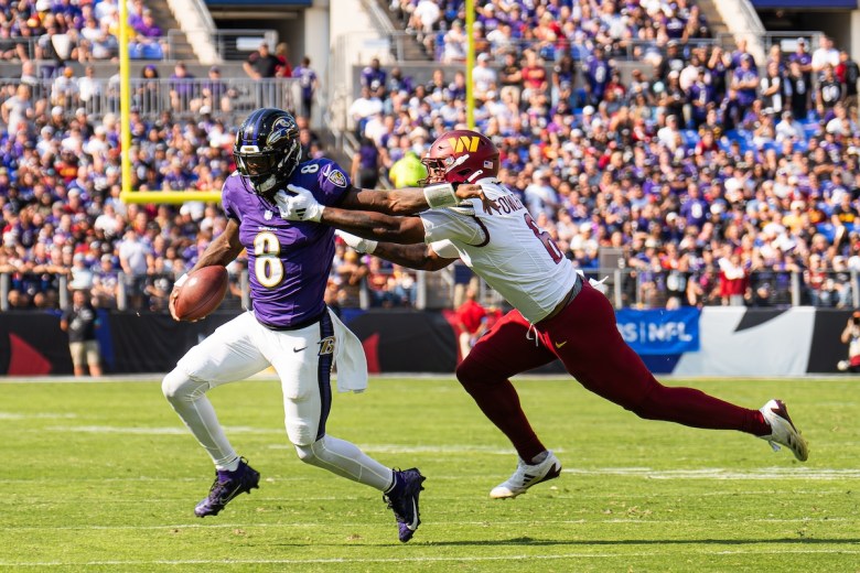 Baltimore Ravens quarterback Lamar Jackson (left) evades Washington Commanders linebacker Dante Fowler Jr. during the Oct. 13 matchup, dubbed the “Battle of the Beltway,” at M&T Bank Stadium in Baltimore. The Commanders lost to the Ravens 30-23. (Abdullah Konte/The Washington Informer)