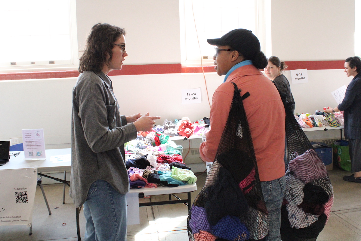 Volunteers and event attendees stop by a clothing/item swap station at a March 30 Zero Waste DC Community Fair hosted by D.C.'s Department of Public Works and Department of Energy and Environment. (Cleveland Nelson/The Washington Informer)