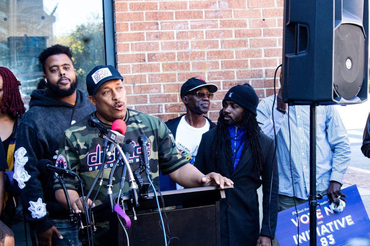 Local leaders, activists and residents including Lil Chris of the go-go band TOB (back left), Ron Moten (center) and Council member Trayon White (right) (Cleveland Nelson/The Washington Informer)