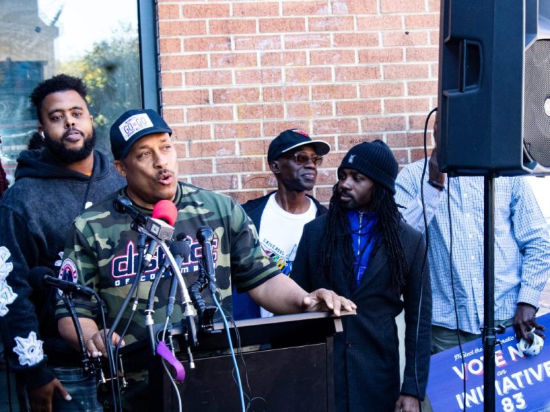 Local leaders, activists and residents including Lil Chris of the go-go band TOB (back left), Ron Moten (center) and Council member Trayon White (right) (Cleveland Nelson/The Washington Informer)