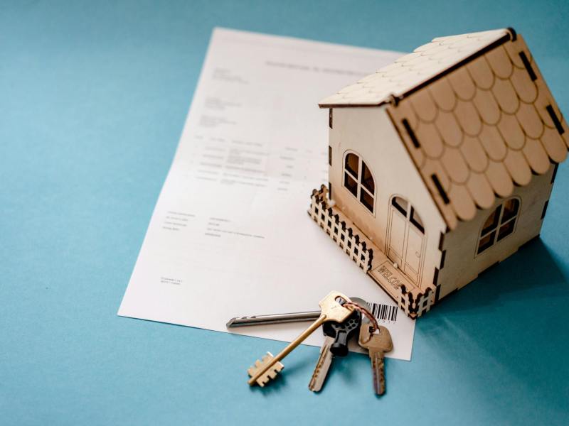 wooden house moder keys and contract on table