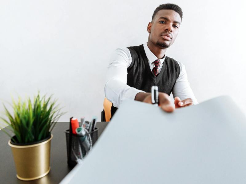 man in white dress shirt sitting at the table