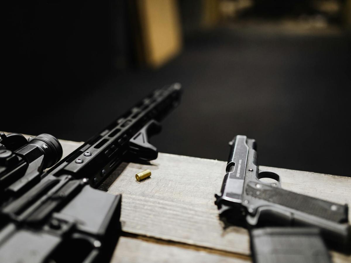 a rifle and a handgun on a desk