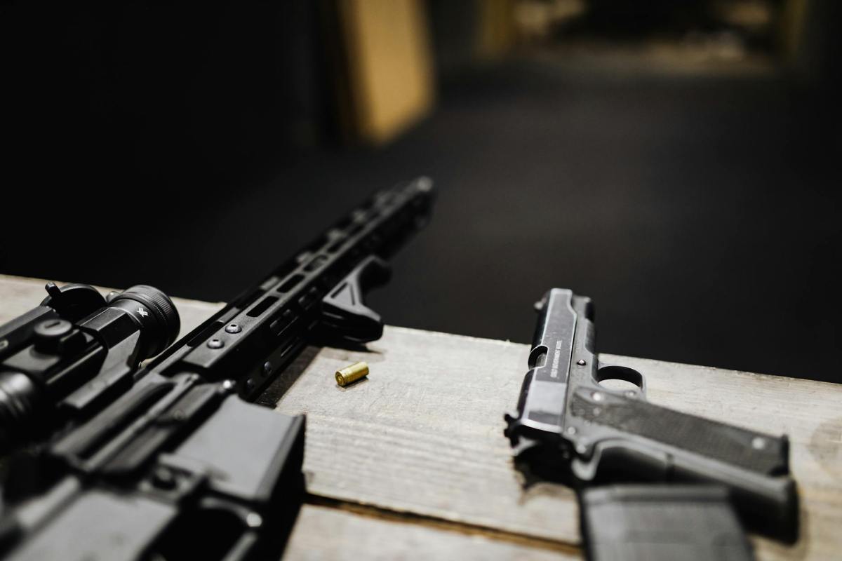 a rifle and a handgun on a desk