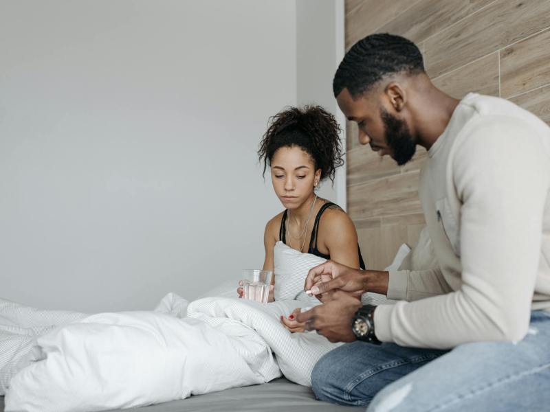 man in long sleeve shirt sitting beside woman in black tank top