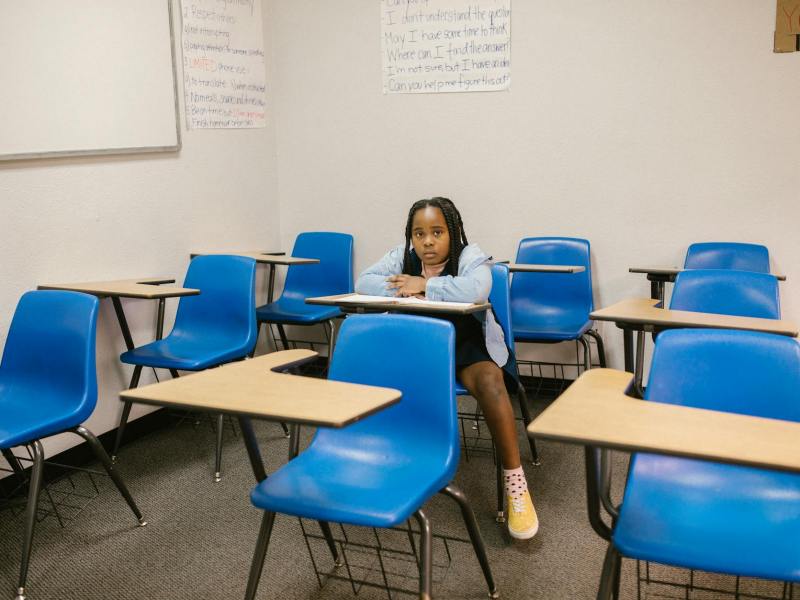 girl sitting on her desk looking lonely