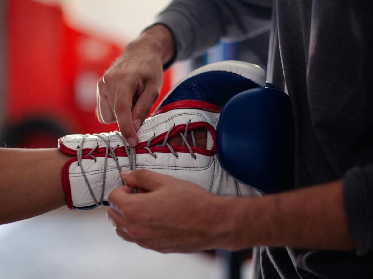 a person tying the laces of a boxing glove